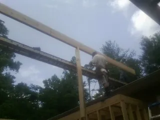 Carpenter setting a ridge beam over a new addition frame — Ice Dam Removal by Roofing Brothers in Voorhees