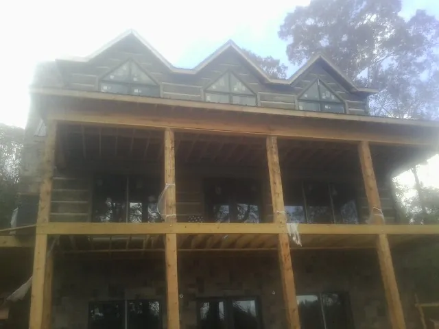 Dormers and porch framing on a large log home under construction — Roof Coating work by our crew in Voorhees