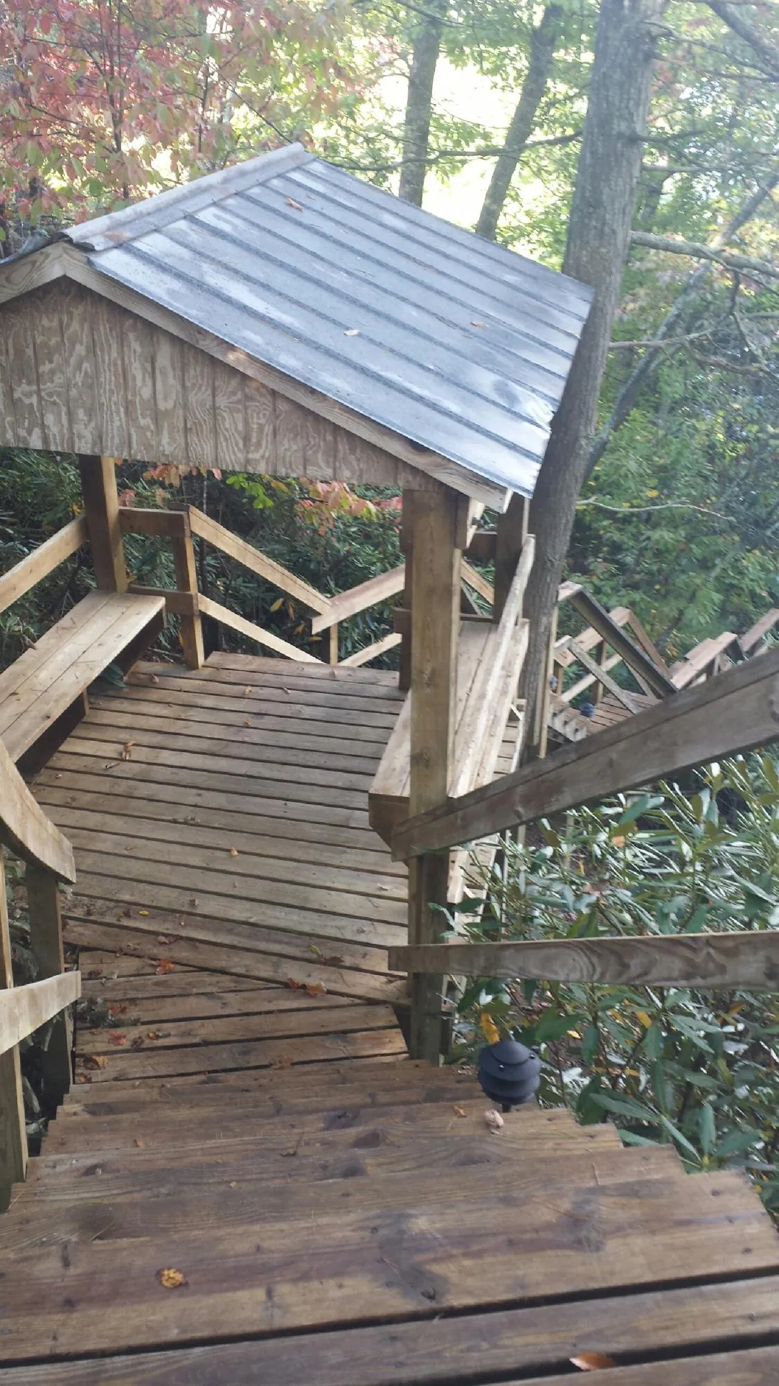 Metal roofed shelter over wooden steps on a wooded walkway — Skylight Repair & Installation work by our crew in Voorhees